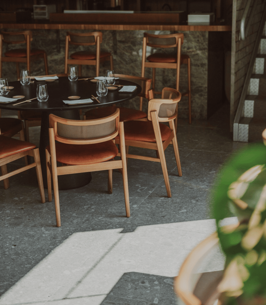 Luxo e Sofisticação: Elevato Casa chega ao site da Elevato 8 Cadeiras Joy, Banquetas Joy e Mesa Colon da Gottems em madeira e estofado, em ambiente sofisticado de jantar.
