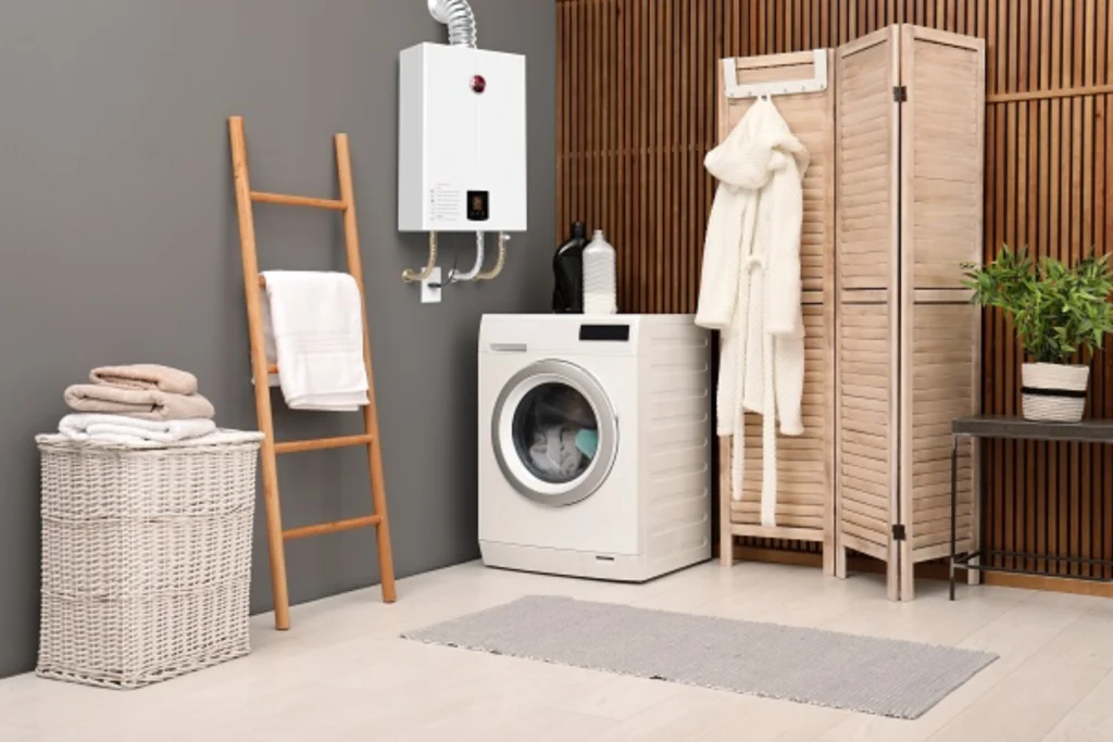 Aquecedor a Gás Rheem: Conforto, Economia e Desempenho em cada banho 2 Lavanderia moderna com aquecedor a gás Rheem instalado na parede, máquina de lavar, cesto de roupas e decoração em tons neutros com detalhes de madeira.